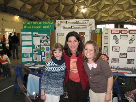 Abby in front of her project with Dr. Soto-Kile and friend, Monica.